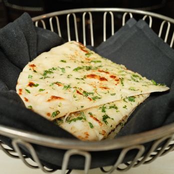 Ananda - Garlic Naan (portions are bigger than the one in the picture, we just ate some already) - Indian Near Me - Fulton, Maryland
