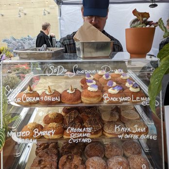 SoDo Donuts - a man behind a display case of donuts - Donuts Near Me - Berkeley, California