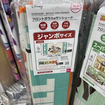 Daiso - A Mickey Mouse sunshade for car windows, featuring Disney branding and cartoon images, is packaged and displayed in a store. - Department Stores Near Me - Jurupa Valley, California