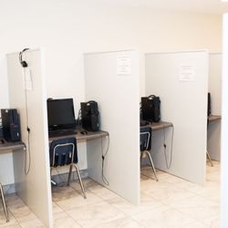 Quality Tutoring Services - Test takers have their own cubicle, separated by partitions including a desktop. mouse, and headphones.