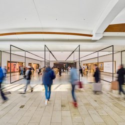 Annapolis Mall - Shoppers walk past the bright, glass-fronted Apple Store inside Annapolis Mall.