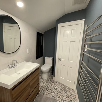 Porcelanosa - a bathroom with a toilet, sink, and mirror - Kitchen & Bath Near Me - Riverside, Connecticut