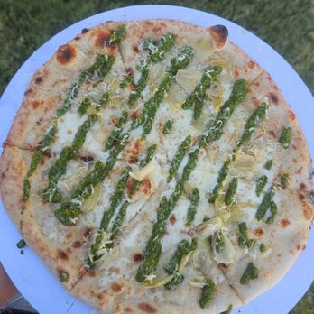 Gee Jays Pizza - The Green One, Garlic Cream, artichoke hearts, mozzarella, provolone, pistachio pesto drizzle - Caterers Near Me Gee Jays Pizza - The Green One, Garlic Cream, artichoke hearts, mozzarella, provolone, pistachio pesto drizzle - Caterers Near Me