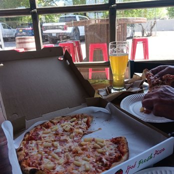 Stone Pine Pizza - a pizza in a pizza box with a slice taken out of it - Food Trucks Near Me - Bend, Oregon