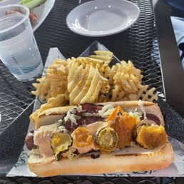 Signature Grand Slam Dog - hot dog wrapped in pastrami, garlic-Mayo ketchup, topped with slaw and fried pickles - $14