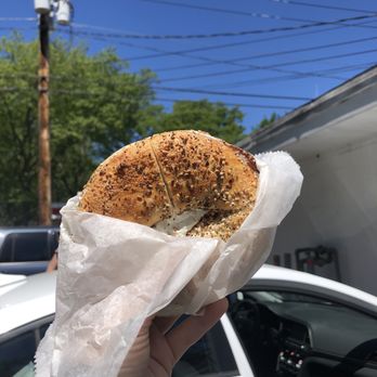 Hampton Bagels - a person holding a bagel in their hand - Bagels Near Me - East Hampton, New York Hampton Bagels - a person holding a bagel in their hand - Bagels Near Me - East Hampton, New York