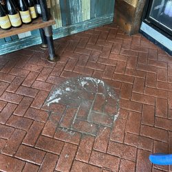 Mighty Clean - Tile and Grout Cleaning completed around a table base to show its previous condition.