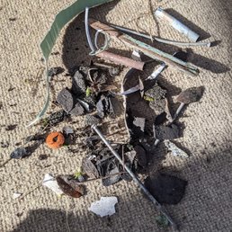different kinds of nails, shingle pieces, parts of siding, paint, and metal cylinders