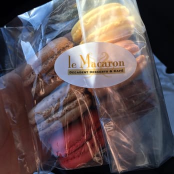 Le Macaron - a hand holding a bag of macarons - Bakeries Near Me - Regina, Saskatchewan