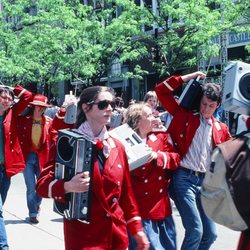 Library Mall - Marchers bumping hips together, on Boom Box Parade on State Street.  See marcher holding child's hand. Photo by Tom Brody.