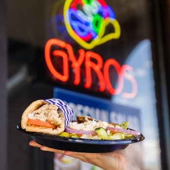 Grecian Gyro - a person holding a plate of food - Greek Near Me - Tucker, Georgia Grecian Gyro - a person holding a plate of food - Greek Near Me - Tucker, Georgia