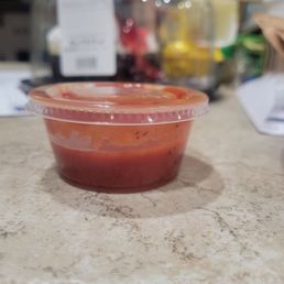 Barely half way filled sauce container for 6 breadsticks