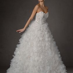 Expressions In Silk Bridal & Prom - This bridal gown has delicate ruffles on the skirt and fully applique and beaded top