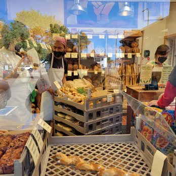 Acme Bread Company - Looking in through window at workers and trays of breads and treats - Bakeries Near Me - Berkeley, California Acme Bread Company - Looking in through window at workers and trays of breads and treats - Bakeries Near Me - Berkeley, California
