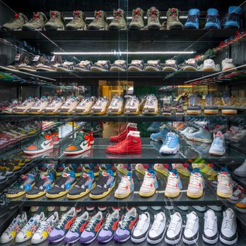 Private Selection - A glass display case showcases a variety of sneakers in different colors and styles, organized on multiple shelves. - Men's Clothing Near Me - Dallas, Texas
