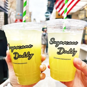 Sugarcane Daddy - two people holding drinks in their hands - Juice Bars & Smoothies Near Me - New York, New York Sugarcane Daddy - two people holding drinks in their hands - Juice Bars & Smoothies Near Me - New York, New York
