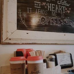 a coffee shop with a chalkboard above it a coffee shop with a chalkboard above it