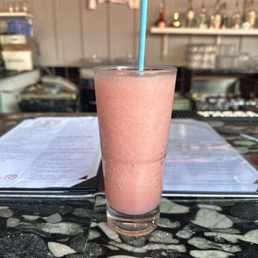 a pink smoothie with a blue straw