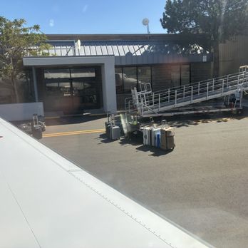 JSX - Luggage as you deplane and in front of the terminal entrance. - Airlines Near Me - Costa Mesa, California