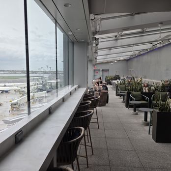 Delta Sky Club - Terminal C - The "sun room" at the far end with a couple of swing-y chairs - Airport Lounges Near Me - Queens, New York