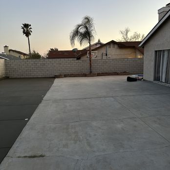Arrieta Landscape - a concrete driveway with a palm tree in the background - Landscaping Near Me
