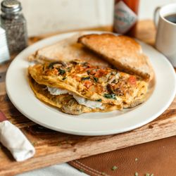 The Bay - The GOAT! Onions, tomatoes, mushrooms, and spinach cooked into a three egg omelette folded over goat cheese!