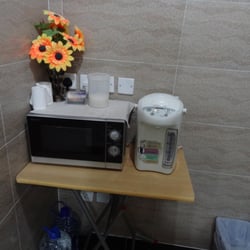 Australian Guest House - microwave and hot pot with bottled water below for the hot pot for guest use.