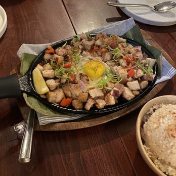 Musang Seattle - Sisig ($28) w/ Sizzling Pork Belly, Onions, Thai Chilies, Fried Egg, Knorr, Scallions, and Lemon - Filipino Near Me - Seattle, Washington Musang Seattle - Sisig ($28) w/ Sizzling Pork Belly, Onions, Thai Chilies, Fried Egg, Knorr, Scallions, and Lemon - Filipino Near Me - Seattle, Washington