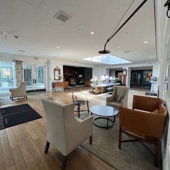 PINE Restaurant - The lobby of the building - The hotel lobby features multiple chairs, a coffee table, and a large skylight ceiling, with natural light illuminating the space. - New American Near Me - Hanover, New Hampshire