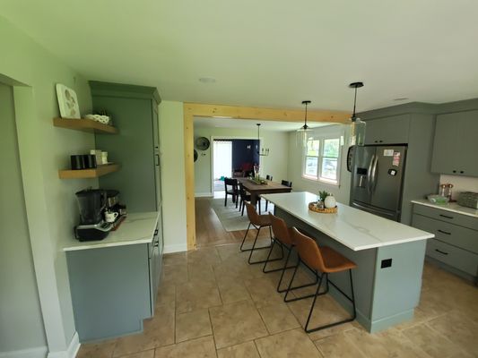 Warminster Farmhouse Kitchen - This was a fun kitchen remodel.  We removed a load bearing wall from between the kitchen and dining room and really opened up the area!  We wrapped that beam in knotty pine to look to give that natural wood beam feeling.  We then added an island to give our clients more storage space and much more counter space.  Our clients were in love with their tile floors so we preserved them.  The color of the cabinets, combined with the maple hood cover really gives this house the rustic feel that our clients were after!