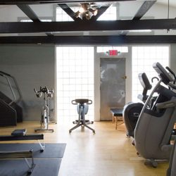 Uptown Fitness - Cardio room: ellipticals, arc trainer, stretch machine, spin bike.