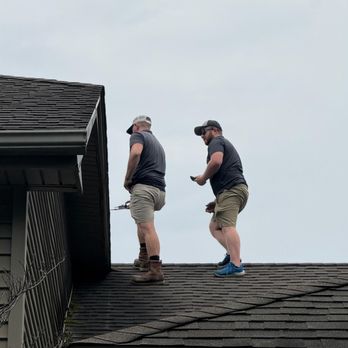 Insideout Inspections - Two home inspectors walking across an asphalt shingle roof to check the roof condition. - Home Inspectors Near Me - Ottawa Lake, Michigan Insideout Inspections - Two home inspectors walking across an asphalt shingle roof to check the roof condition. - Home Inspectors Near Me - Ottawa Lake, Michigan