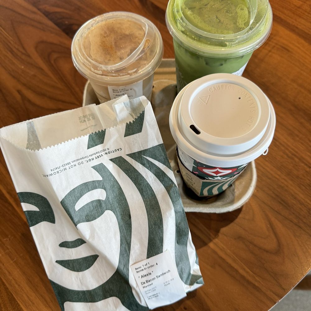 two cups of coffee and a paper bag on a table two cups of coffee and a paper bag on a table