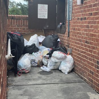 Clairmont at Perry Creek - Garbage outside of the compactor. - Apartments Near Me - Raleigh, North Carolina