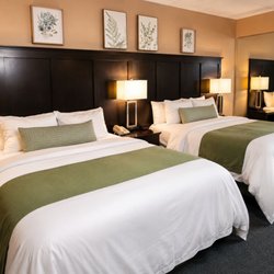 Alleghany Inn - Updated Comfort room featuring 2 queen beds with dark headboards & green accents at Alleghany Inn Blue Ridge in the heart of Sparta, NC.