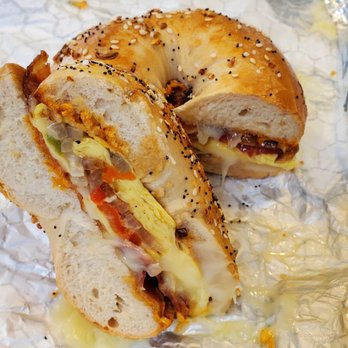 Shirley's Bagels - Santa Fe breakfast sandwich on an Everything bagel. Great! Grilled onions/peppers, bacon, egg, and Chipotle spread. But needs more spread. - Bagels Near Me - Costa Mesa, California