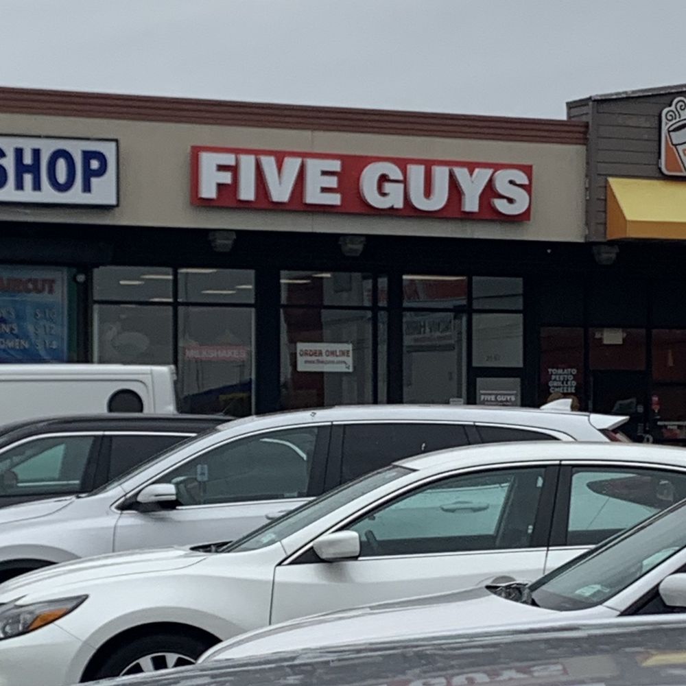 a row of parked cars in front of a dunkin donuts store