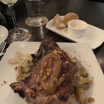 Cedric's Tavern - Estate raised pork chop with roasted cabbage and scalloped potatoes with glass of Biltmore Estate Pinot Grigio. - Pubs Near Me - Asheville, North Carolina