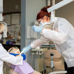 Milwaukee Career College - Dental assistant student and instructor working on a simulation patient in a dental lab setting.