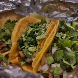 Ground beef tacos with onions and cilantro.