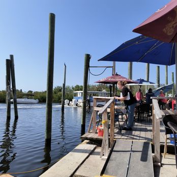 Bayou Bistro - a woman standing on a dock with an umbrella over her head - Seafood Near Me - Tarpon Springs, Florida Bayou Bistro - a woman standing on a dock with an umbrella over her head - Seafood Near Me - Tarpon Springs, Florida