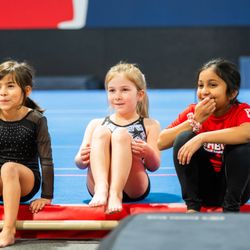 Happy girls sitting together learning gymnastics.