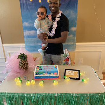 Todos Supermarket - a man holding a baby in front of a cake - Grocery Near Me - Woodbridge, Virginia