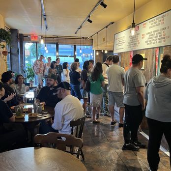 Formosa - Back looking towards entrance - A line of customers waits at a restaurant counter inside a Brooklyn eatery, with some seated at tables and others waiting in line. - Taiwanese Near Me - Brooklyn, New York