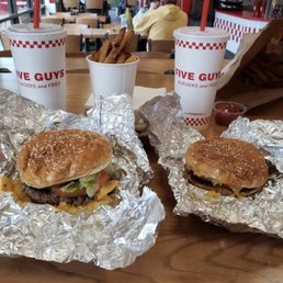 two burgers and fries on a table two burgers and fries on a table