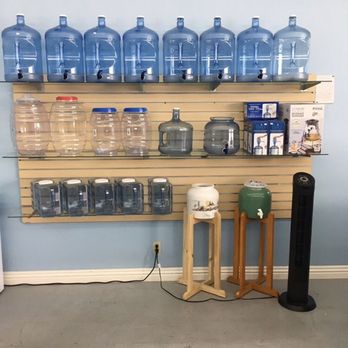 Water-Loo - a shelf of water bottles and a water dispenser - Water Stores Near Me - Santa Ana, California