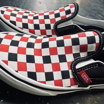 Vans - The shoes my son got for $17 on sale! - Vans slip-on shoes featuring a red, black, and white checkered fabric pattern, with black and white accents and a Vans logo tag. - Shoe Stores Near Me - Phoenix, Arizona