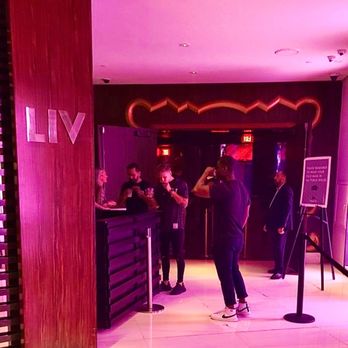 LIV Nightclub - a group of people standing in front of a bar - Dance Clubs Near Me - Miami Beach, Florida