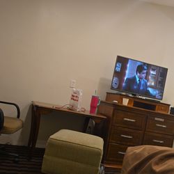 Red Carpet Inn - TV, dresser slash fridge.