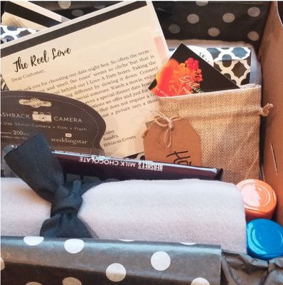 The Reel Box - Date Night Box - Our "Reel Love" date box comes loaded with everything needed to have a "me and you" moment relaxing while the rush and bustle of your busy day takes a back seat to enjoy a beautiful date. 

What's in my Box
2 blankets
Popcorn and Popcorn cups
Popcorn seasoning
Delicious Hot Chocolate mix
2 Hot tumblers
Large chocolate bar
Sure-shot disposable camera
Red Box -promotional code (if unable to stream movie)
Suggested move listing
Online Movie Trivia